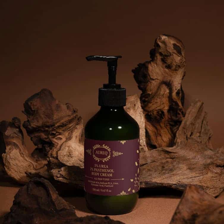 AUREQ 5% urea panthenol body cream pump bottle on natural wood backdrop, intensive hydration and skin barrier repair